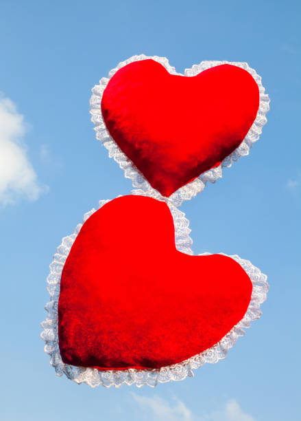 istock Two red heart shaped cushions against the sky 1145664849