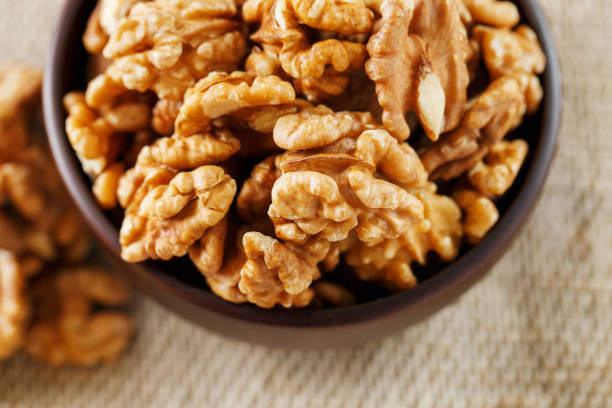 istock Peeled walnuts in a wooden, dark brown cup on a burlap cloth. 1145666996