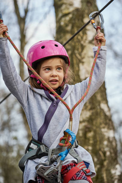 menina adorável no capacete no parque da corda na floresta - education high up sport sports helmet - fotografias e filmes do acervo