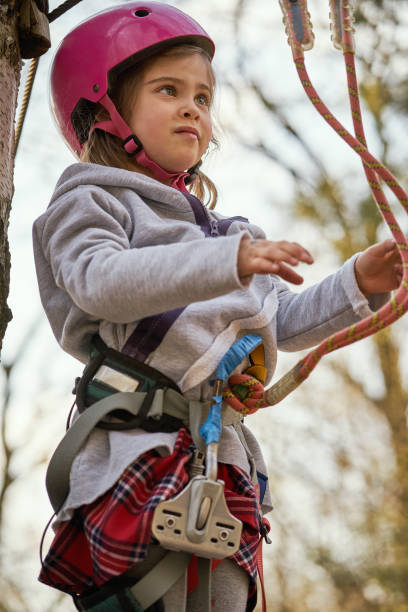 menina adorável no capacete no parque da corda na floresta - education high up sport sports helmet - fotografias e filmes do acervo