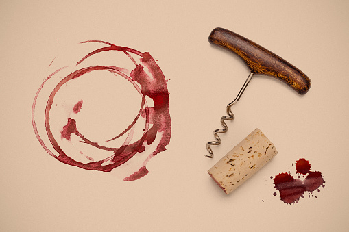 Top view of red wine glass stains with a vintage corkscrew and wine cork stopper shot on sepia toned background. Predominant color is brown. DSRL studio photo taken with Canon EOS 5D Mk II and Canon EF 100mm f/2.8L Macro IS USM.