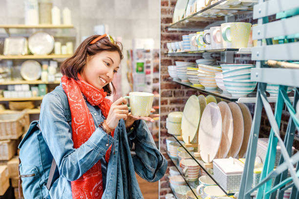 azjatycka dziewczyna zakupy dla przyborów kuchennych w sklepie detalicznym - kitchenware magazyn zdjęcia i obrazy z banku zdjęć