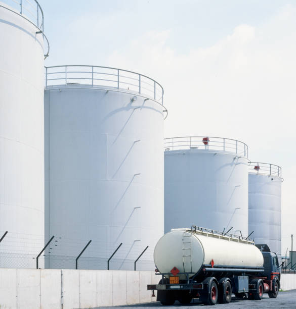 road tanker and oil tanks road tanker in front of oil refinery tanks, neutral with copy space tanker stock pictures, royalty-free photos & images