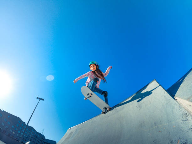 스케이트 파크 램프의 가장자리에 서 있는 어린 소녀 - skateboard park 이미지 뉴스 사진 이미지