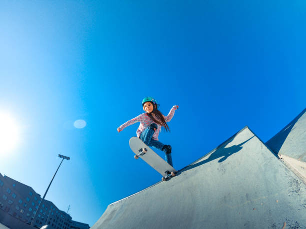 little girl standing on the edge of the skatepark ramp - blue helmets imagens e fotografias de stock