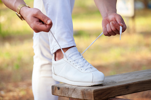 Young man tying shoelace
