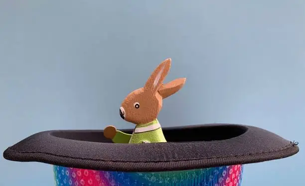 Photo of Green rabbit in magic hat, blue background