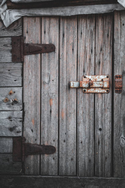 istock Old wooden door and rusty deadbolt in a small barn 1145682937