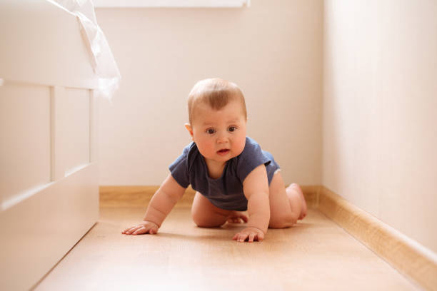 crawling funny baby boy indoors at home - baby tile crawling tiled floor imagens e fotografias de stock