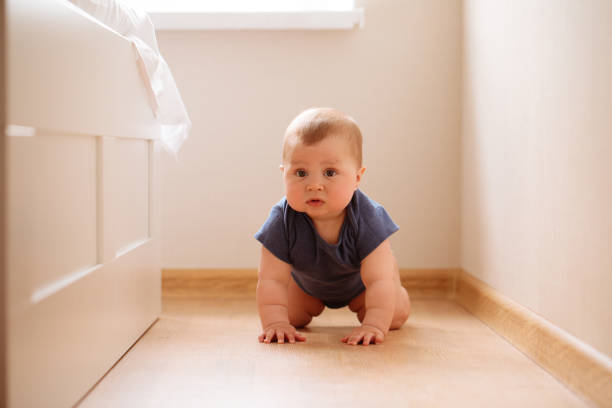 crawling funny baby boy indoors at home - baby tile crawling tiled floor imagens e fotografias de stock