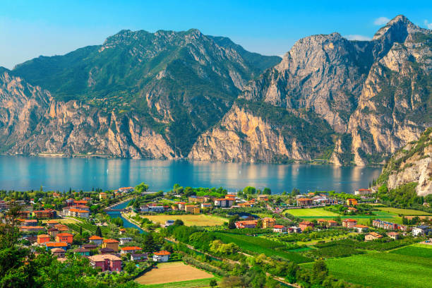 Fantastic Torbole cityscape with plantations and lake Garda, Italy, Europe Breathtaking summer travel and recreation destination. Summer holiday location with lake Garda and Torbole touristic town, Italy, Europe lake garda photos stock pictures, royalty-free photos & images