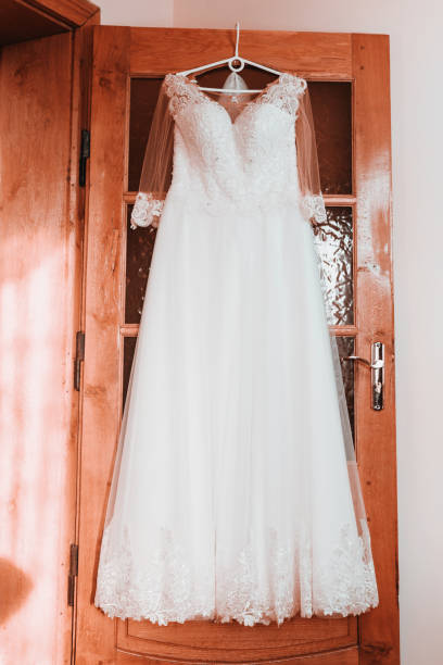 istock wedding dress on hanger on a wall, Beautiful gown 1145687561