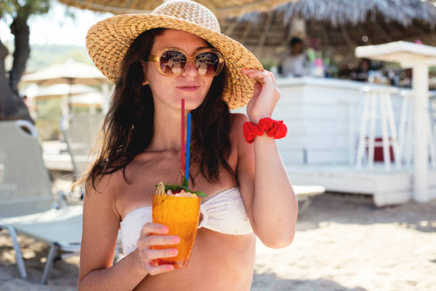 istock Woman holding a fruit cocktail on a tropical beach 1145687724