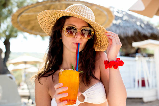istock Woman holding a fruit cocktail on a tropical beach 1145690312