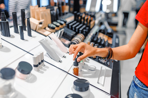 mujer elige cosméticos y productos de maquillaje en una tienda photo