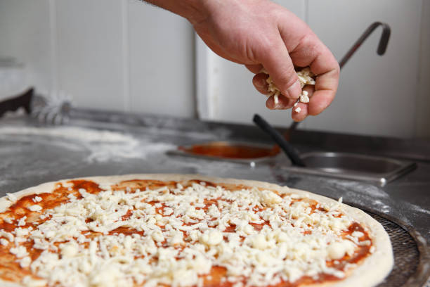 istock The hands of chef sprinkles the pizza with cheese 1145692516