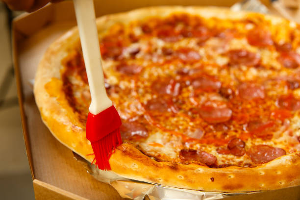 der küchenchef bereitet pizza schmieröl mit einem kochbürsten - ready to cook flash stock-fotos und bilder