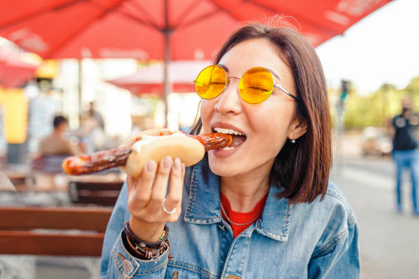 mulher que come a salsicha alemão do fast food do currywurst no café ao ar livre do alimento de rua - german culture people women germany - fotografias e filmes do acervo