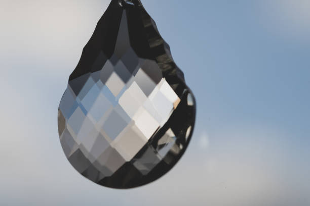 Out of focus image of light refracted through a glass crystal hanging on a window pane, refracting the light from a garden on the other side of the window.  Belfast, Northern Ireland.
