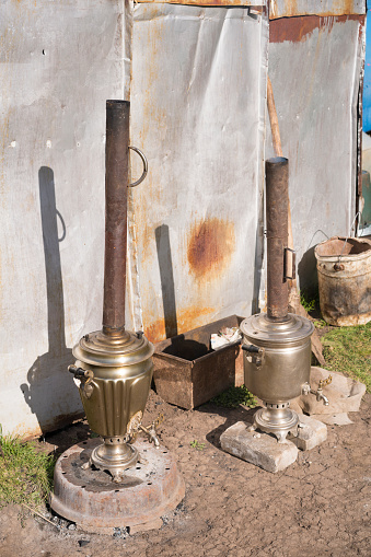 Two Samovars outside the Yurt. It is tradition to boil water for tea in them. They are prized for craftmanship, and keep the water hot all the time. They use coal for heating. It is a place where tourist eat on three days horseback riding from near Kochkor to to Lake Song-Kul in Kyrgyzstan.