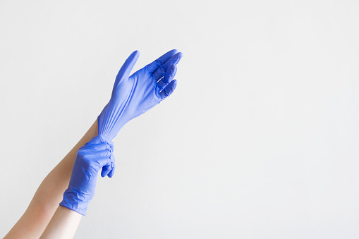 Hand with pink rubber glove holding cleaning brushes , isolated on white background