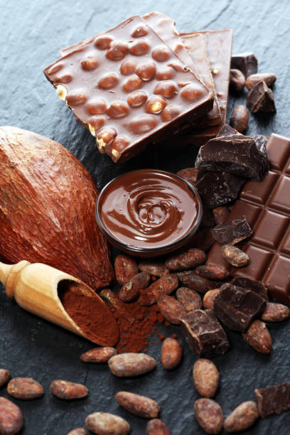 istock Melting chocolate or melted chocolate with a chocolate swirl and stack, chips and powder on black 1145698598
