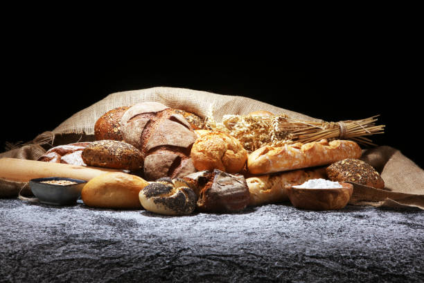 istock Assortment of baked bread and bread rolls on rustic grey bakery table background 1145699816