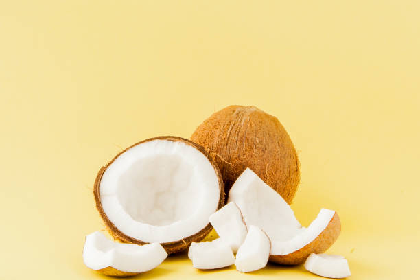 istock close up fresh coconut pieces isolated on a yellow background, tropical fruit concept, flat lay, pop art, copy space 1145704975