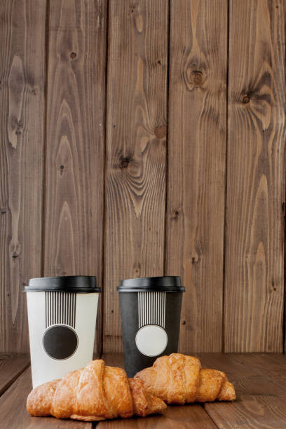 istock Paper coffee cup and croissants on wooden background, Copy space 1145705004