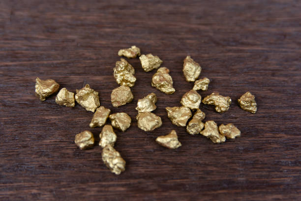 istock mound of gold nugget on dark wood background 1145706211