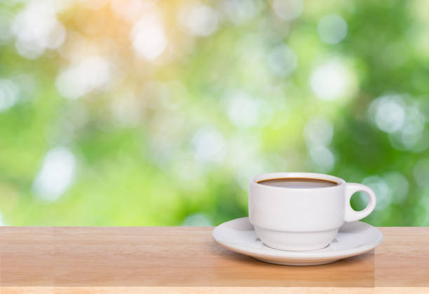 istock Empty wood table top and coffee cup blur nature background with copy space for display or montage your products 1145706479