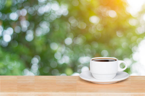 istock Empty wood table top and coffee cup blur nature background with copy space for display or montage your products 1145707408