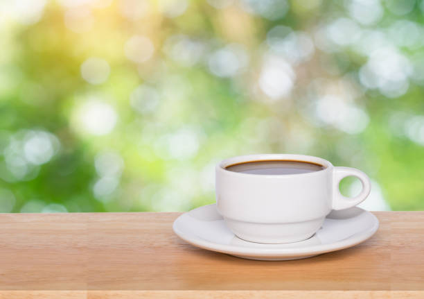 istock Empty wood table top and coffee cup blur nature background with copy space for display or montage your products 1145707635