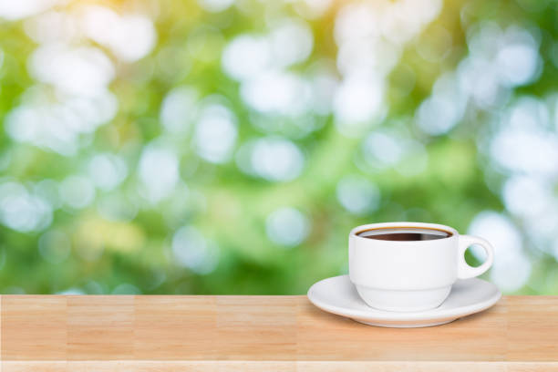 istock Empty wood table top and coffee cup blur nature background with copy space for display or montage your products 1145707652