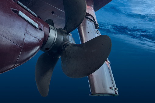 Propeller and rudder of big ship underway view from underwater. Close up image detail of ship. Transportation industry. Freight transportation. Ship repair, underwater survey and shipping business concept.