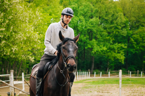 istock Young man is enjoying horseback riding in nature 1145709088