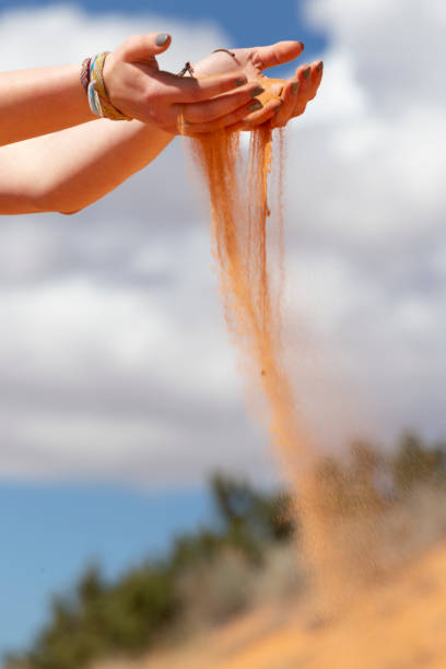 istock Hands Releasing Colorful Pink Beach Sand 1145709113