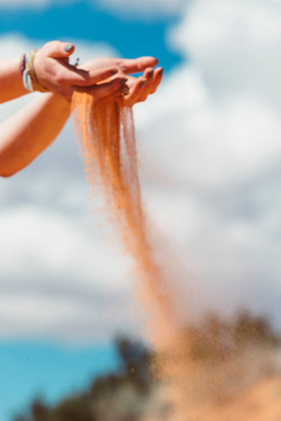 istock Hands Releasing Colorful Pink Beach Sand 1145709123