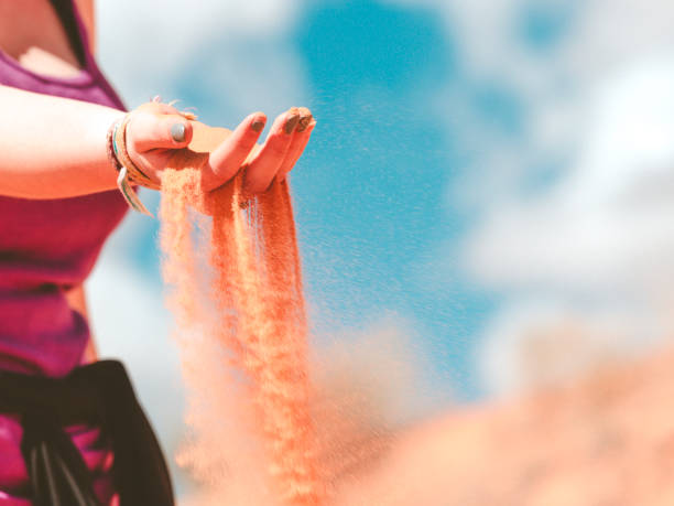 istock Hands Releasing Colorful Pink Beach Sand 1145709223