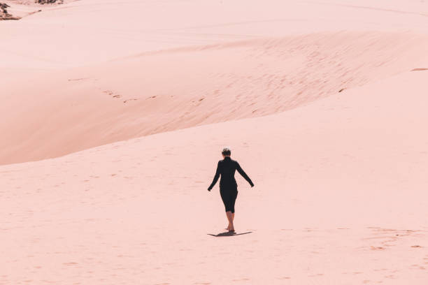 istock Woman Walking on Pink Sand Beach Desert 1145709878