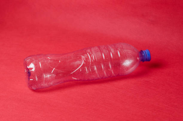 istock Plastic empty bottle on a red background with space for text. Concept of environmental pollution by polyethylene waste 1145712185