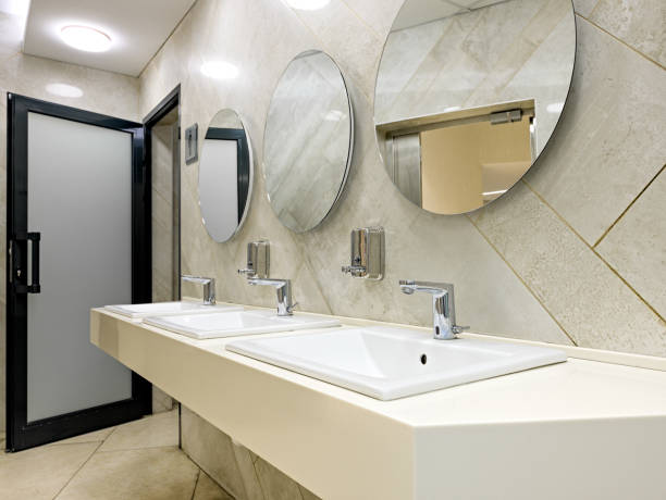 public restroom with sinks faucets and mirrors - urinal clean contemporary in a row imagens e fotografias de stock