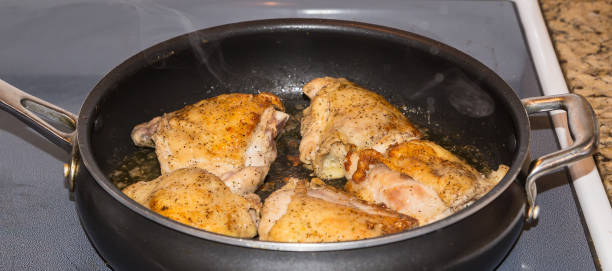 Chicken Thighs Being Seared Skin Side Up stock photo