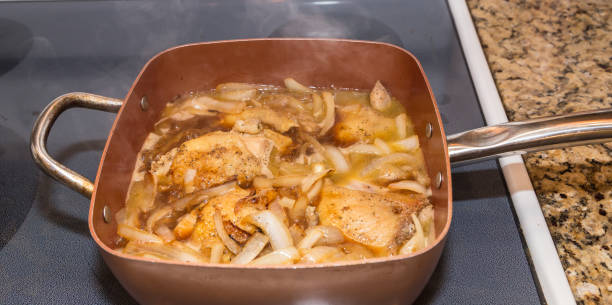 Chicken Thighs and Sauteed Onions Basting in Pino Grigio stock photo