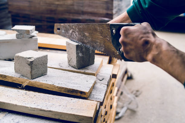 istock Close up on the construction worker using the hand saw to manually cut the brick insulation material concrete stone 1145717230