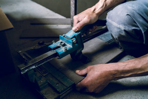istock Close up on construction worker craftsman using tool for cutting ceramic tiles for laying installation to the bathroom 1145720839
