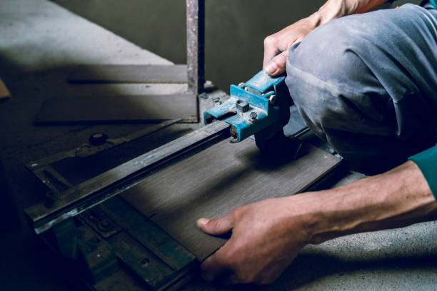 istock Close up on construction worker craftsman using tool for cutting ceramic tiles for laying installation to the bathroom 1145720840