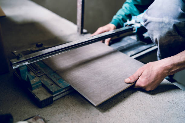 istock Close up on construction worker craftsman using tool for cutting ceramic tiles for laying installation to the bathroom 1145720922