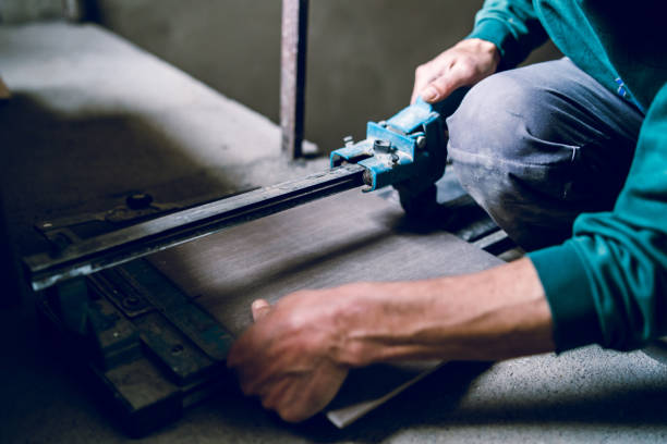 istock Close up on construction worker craftsman using tool for cutting ceramic tiles for laying installation to the bathroom 1145721756