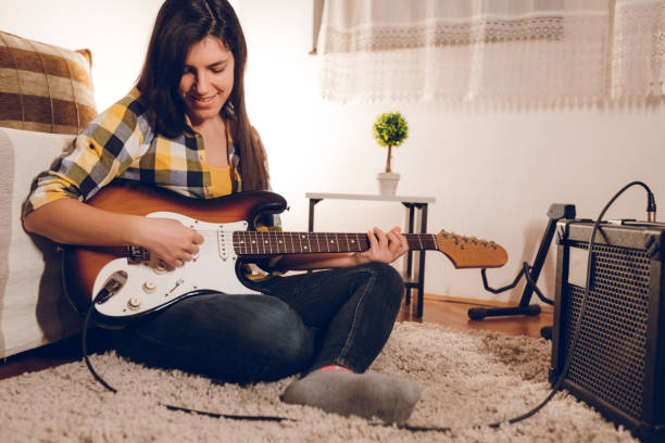 istock Young woman playing electric guitar 1145723524